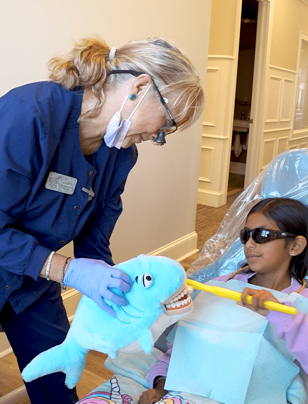 Shark (1) Patient sitting in dental chair touching touch screen of x-ray image