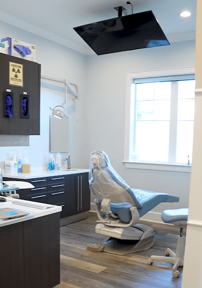Room (1) (1) Patient sitting in dental chair touching touch screen of x-ray image